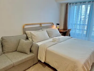 a bedroom with a large bed and a couch at Pod to Go in Manila