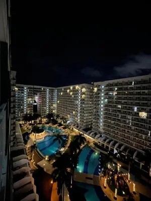 a large building with two swimming pools at night at Sparkling Shell Residences Kaeri Properties in Manila