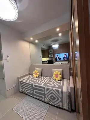 a bedroom with a large bed with flowers on it at Staycation, Mall of Asia in Manila
