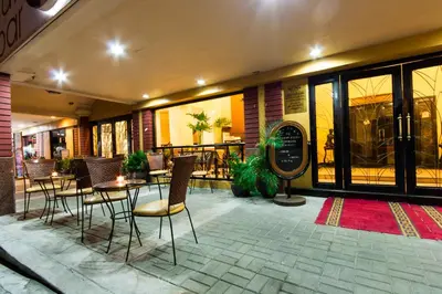 a restaurant with chairs and tables in a building at Miramar Hotel in Manila