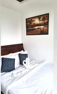 a bed with white sheets and a picture on the wall at Birch Tower Big Studio Type Unit 2711 in Manila
