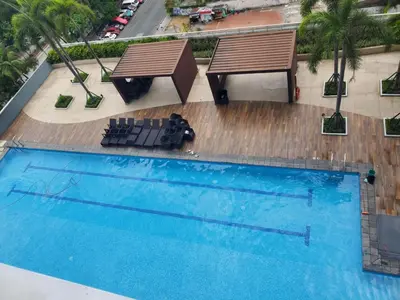 an overhead view of a pool with two benches and a table at La Luz - SMDC Breeze Residences in Manila