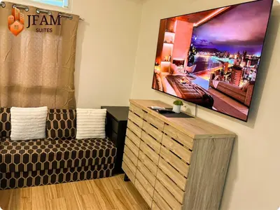 a living room with a couch and a flat screen tv at JFam Suites, C3-9D Studio, Up To 4 Pax in Biñan