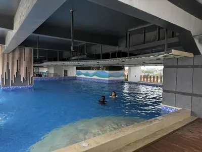 a person swimming in a large swimming pool at Modern 1 bedroom w Pool and City Views in Manila