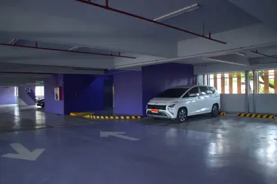 a white car parked in an empty parking garage at Modern 1 bedroom w Pool and City Views in Manila