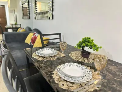 a table with two plates and glasses on it at AdahkuMaya Luxury Suites in Manila
