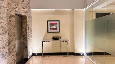 a hallway with a table and a picture on the wall at AdahkuMaya Luxury Suites in Manila