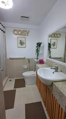 a bathroom with a sink and a toilet and a mirror at Mysuites2go 517 Lenden in Manila