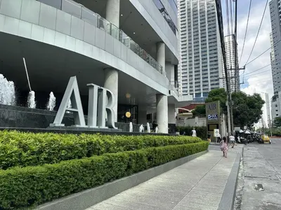 a girl walking down a sidewalk in front of a building at Makati City Ph SnowWhite Staycation in Manila