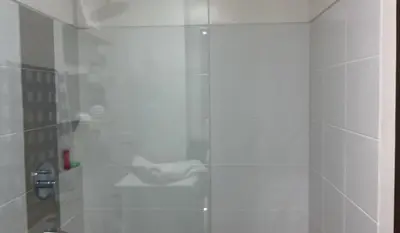 a bathroom with a shower with a glass door at The Olive Place, Manadaluyong City in Manila