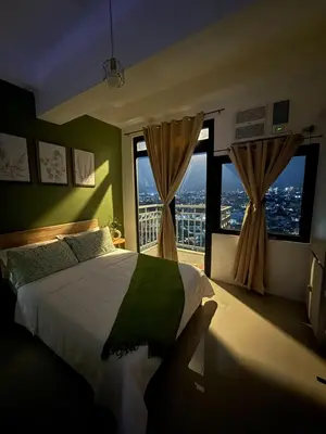 a bedroom with a large bed and large windows at Harbour Park Residences Cozy 1BR Suite in Manila
