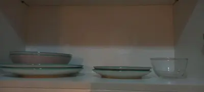 three bowls and a glass sitting on a shelf at Megaworld in Manila
