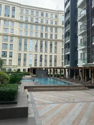 a building with a swimming pool in front of a building at Megaworld in Manila