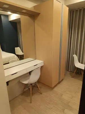 a room with a desk and a bed and a mirror at Megaworld in Manila