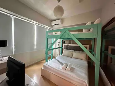 a bedroom with a bunk bed with a desk and a computer at Cozy House BGC 1BR up to 6 Guests 100MBPS WiFi in Manila