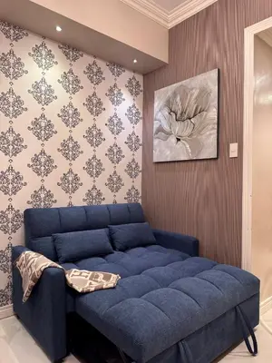 a blue couch in a room with a wall at Charming Unit at Smdc Sun Residences in Manila