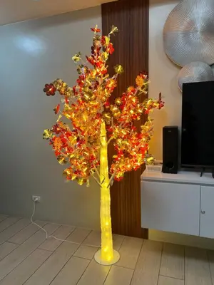 a yellow vase with a christmas tree in a room at Cozy Condo Unit Near NAIA Terminal 3 in Manila