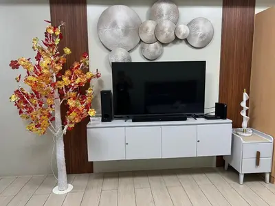a living room with a television on a white cabinet at Cozy Condo Unit Near NAIA Terminal 3 in Manila