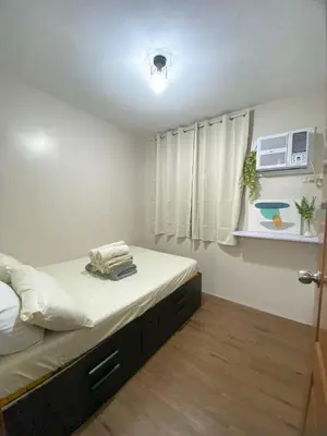 a small bedroom with a bed with white sheets at Your Comfort Zone Staycation3 in Manila