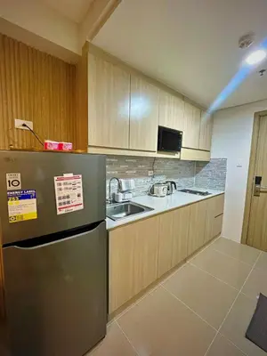 a kitchen with a refrigerator and a sink at Shore 1 Residences - ÜniQa Suite - MOA Area in Manila