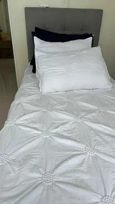 a white bed with white sheets and pillows at South Residences Tower 4, Las Pinas in Manila
