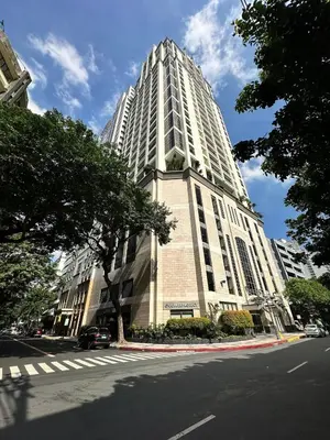 a tall white building on a city street at Stylish 100 SQM 3BR Loft Near Greenbelt Makati in Manila