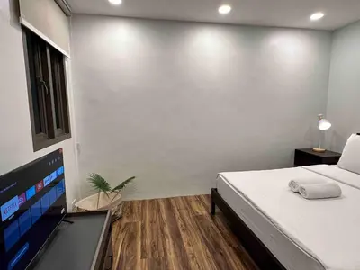 a bedroom with a bed and a flat screen tv at Huge 100-SQM 3BR Loft near Greenbelt Makati in Manila