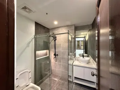 a bathroom with a shower and a toilet and a sink at Huge 100-SQM 3BR Loft near Greenbelt Makati in Manila