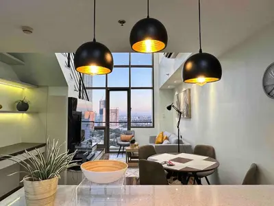 a kitchen and living room with a large window at Huge 100-SQM 3BR Loft near Greenbelt Makati in Manila
