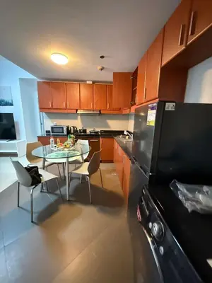 a kitchen with a small table and a refrigerator at Executive Suites Bellagio Golf View Residences in Manila