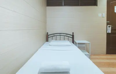 a bedroom with a bed in a room with a door at Maine Residences Leveriza by RedDoorz in Manila
