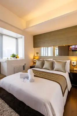 a large bedroom with two beds and a window at Luxurious Studio in McKinley Hill with City View in Manila