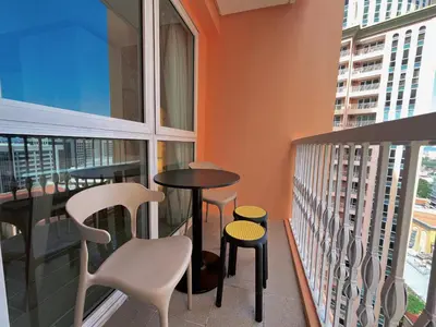 a balcony with a table and chairs and windows at PREMIUM 1BR Venice Canal Mall, Pool, Gym, Sauna & 5G Wi-Fi, Ste 16 in Manila