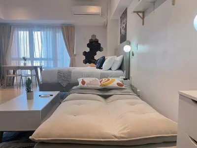 a hotel room with two beds and a table at PREMIUM 1BR Venice Canal Mall, Pool, Gym, Sauna & 5G Wi-Fi, Ste 16 in Manila