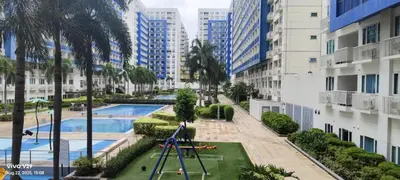 an apartment complex with a playground and a swimming pool at Graxia staycation in Manila
