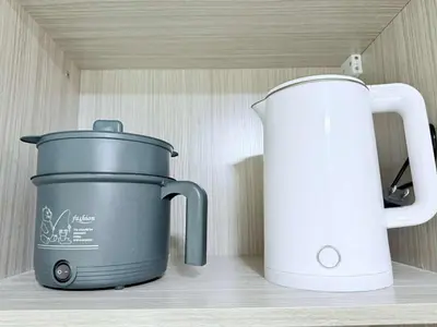 a slow cooker and a toaster sitting on a shelf at Cozy Place to Stay in Manila