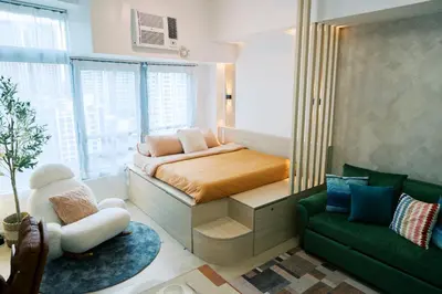a small bedroom with a bed and a couch at Breathtaking Eastwood City View, 3min walk to Malls, with Washer in Manila