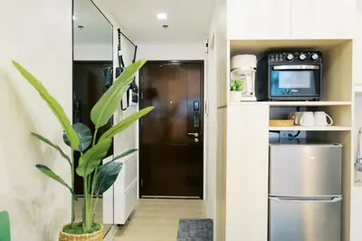 a kitchen with a black door and a plant at Breathtaking Eastwood City View, 3min walk to Malls, with Washer in Manila