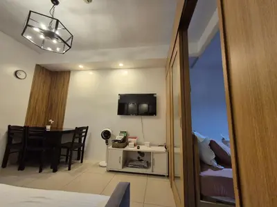 a room with a bed and a dining room with a table at Family Suite with Big Balcony and Pool View in Manila