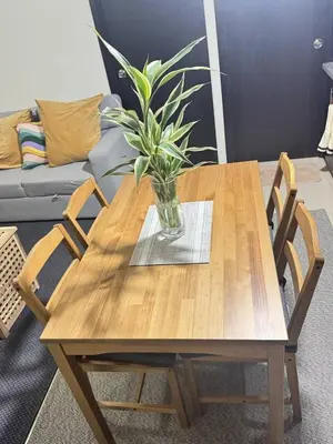 a wooden table with a vase with a plant on it at City Lights and Cozy nights in Manila