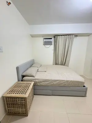 a small bedroom with a bed and a window at City Lights and Cozy nights in Manila
