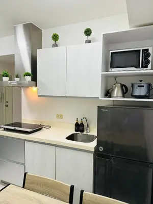 a kitchen with a sink and a black refrigerator at Affordable Boracay-like Staycation in Azure South in Manila