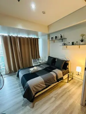 a bedroom with a large bed and a window at Affordable Boracay-like Staycation in Azure South in Manila
