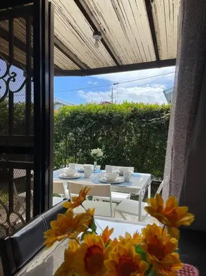 a table and chairs on a balcony with flowers at Relaxing 3bedroom home with outdoor dining NUVALI in Calamba