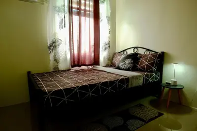 a bed sitting in a room with a window at Cecils Cubao Cozy Escape in Manila