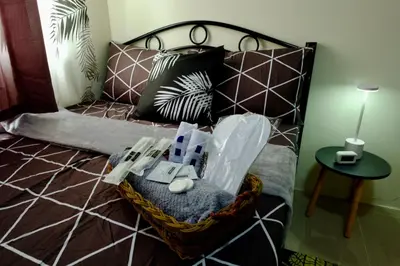 a bedroom with a bed with a bed frame and pillows at Cecils Cubao Cozy Escape in Manila