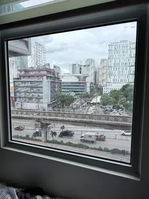 a window with a view of a city with buildings at Cecils Cubao Cozy Escape in Manila