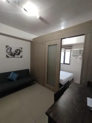 a small room with a couch and a bed at Shore D 1422 in Manila