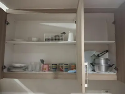 a kitchen cabinet filled with dishes and utensils at Shore D 1422 in Manila