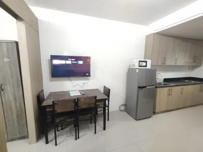 a small kitchen with a table and a refrigerator at Shore D 1422 in Manila